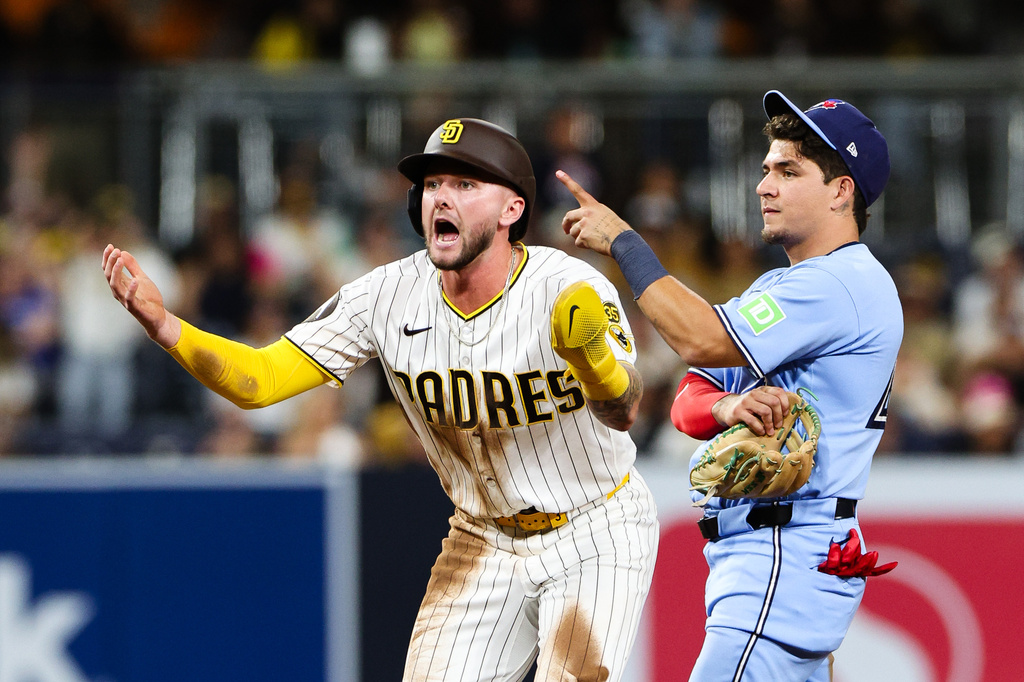 San Diego Padres' Jackson Merrill, left, reacts after the team challenged the out call on an attempted steal at second base as Toronto Blue Jays' Luis Urías looks on in the eighth inning of a baseball game Saturday, July 11, 2026, in San Diego. (AP Photo/Derrick Tuskan)