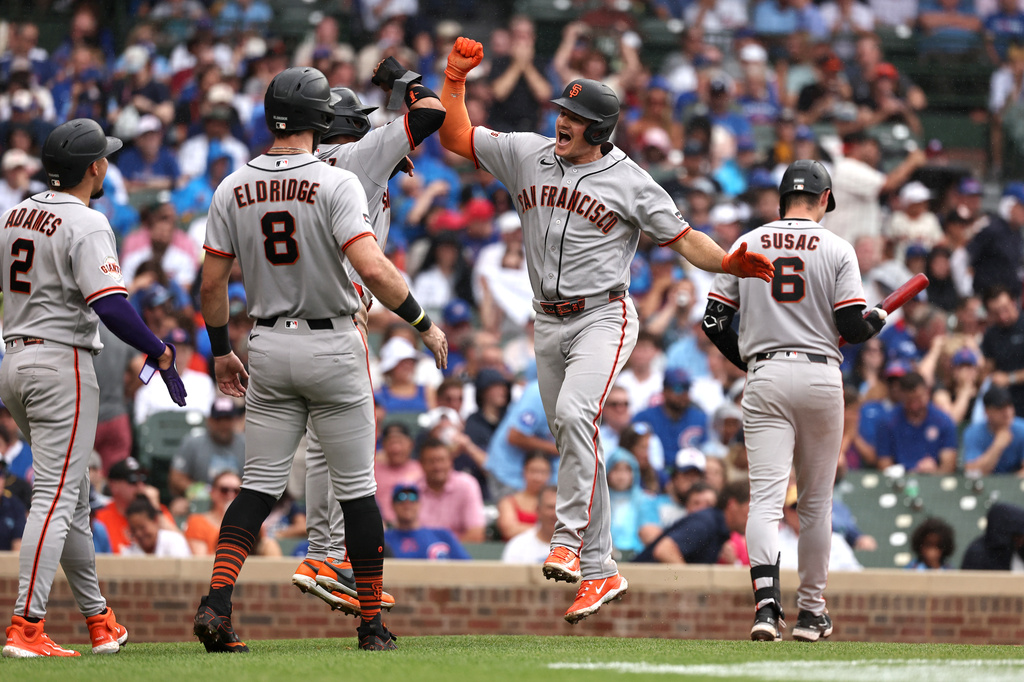 San Francisco Giants' Matt Chapman, center, celebrates hitting a grand slam with teammates Luis Arraez (1) hidden, Bryce Eldridge (8) and Willy Adames (2) during the fourth inning of a baseball game against the Chicago Cubs at Wrigley Field, Friday, June 5, 2026, in Chicago. (AP Photo/Geoff Stellfox)