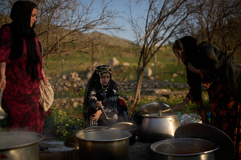 Women wearing traditional clothes prepare Iftar meal as they take part in a family gathering during the Muslim holy month of Ramadan in the village of Gulp, Iraq, Tuesday, March 17, 2026. (AP Photo/Leo Correa)