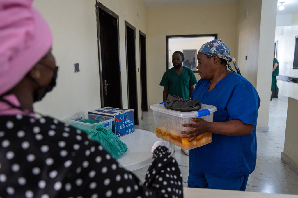 A health worker receives food for medical staff and Ebola patients at the Evangelical Medical Center (CEM) in Bunia, Congo, Monday, June 1, 2026. (AP Photo/Moses Sawasawa)