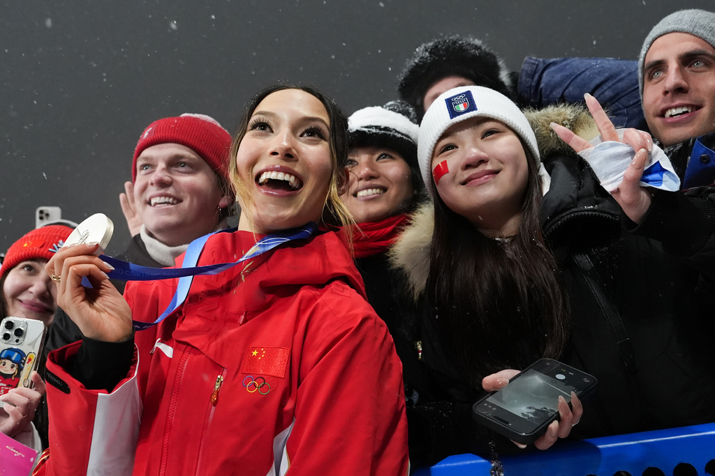 Silver medalist China's Eileen Gu celebrates with fans after the women's freestyle skiing big air finals at the 2026 Winter Olympics, in Livigno, Italy, Monday, Feb. 16, 2026. (AP Photo/Gregory Bull)