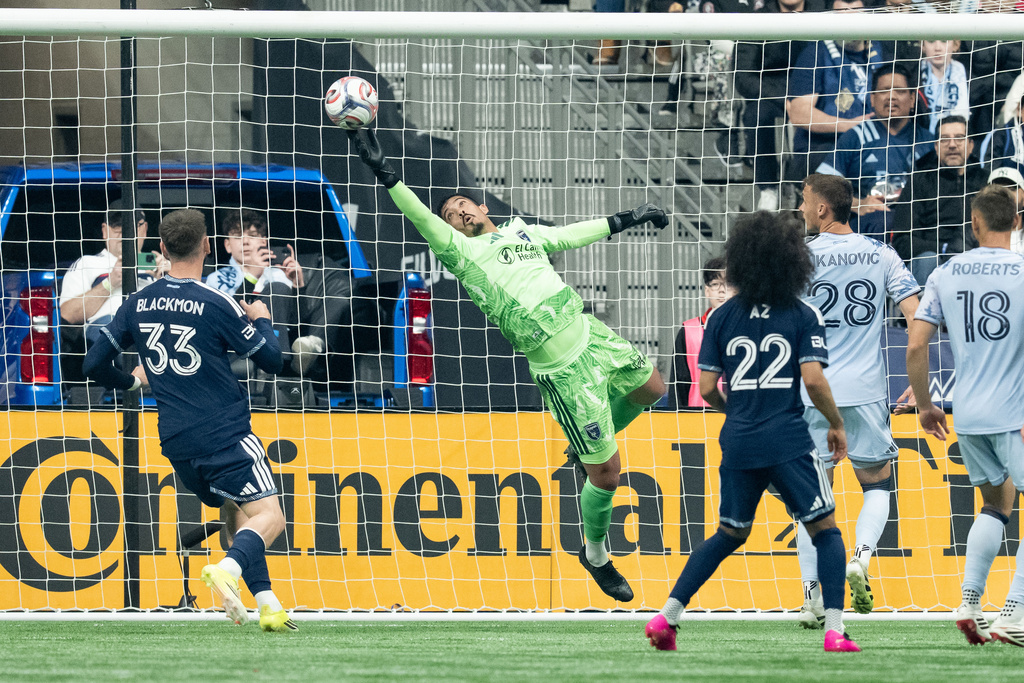San Jose Earthquakes goalkeeper Daniel (42) makes a save as Benji Kikanovic (28), Reid Roberts (18), Vancouver Whitecaps' Tristan Blackmon (33) and Aziel Jackson (22) watch during the first half of an MLS soccer match in Vancouver, on Saturday, March 21, 2026. (Ethan Cairns/The Canadian Press via AP)
