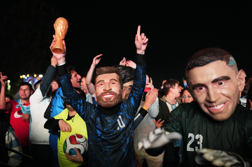 Fans with masks of Argentina's Lionel Messi, center, and Emiliano Martinez gather to watch the World Cup soccer match between Argentina and Algeria in Buenos Aires, Argentina, Tuesday, June 16, 2026. (AP Photo/Rodrigo Abd)