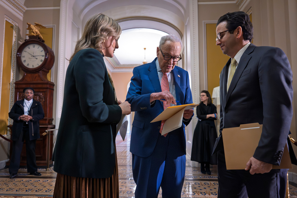 Senate Minority Leader Chuck Schumer, D-N.Y., center, confers with an aide, left, and Sen. Brian Schatz, D-Hawaii, following a Senate Democratic Caucus meeting, at the Capitol in Washington, Tuesday, Feb. 3, 2026. (AP Photo/J. Scott Applewhite)