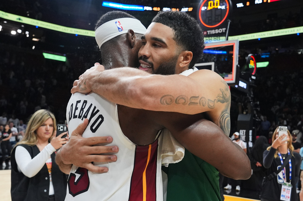 Miami Heat center Bam Adebayo (13) and Boston Celtics forward Jayson Tatum, right, embrace after an NBA basketball game, Wednesday, April 1, 2026, in Miami. (AP Photo/Lynne Sladky)