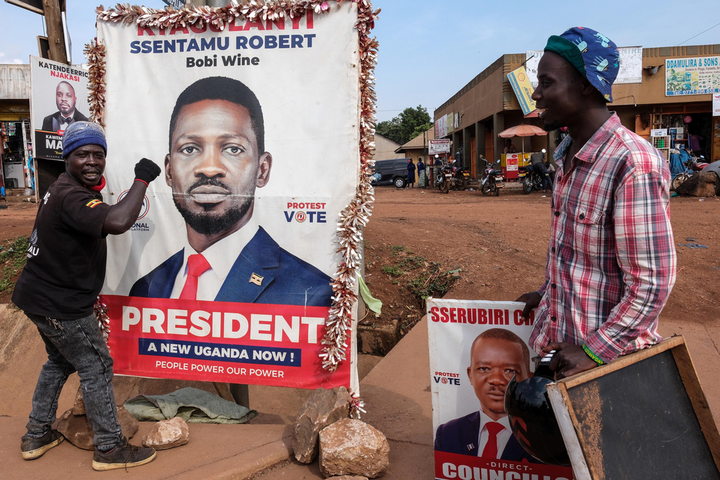 A supporter of Uganda opposition presidential candidate Robert Kyagulanyi Ssentamu, known as Bobi Wine, holds onto a campaign poster in Kampala, Uganda, Tuesday, Jan. 13, 2026. (AP Photo/Samson Otieno)