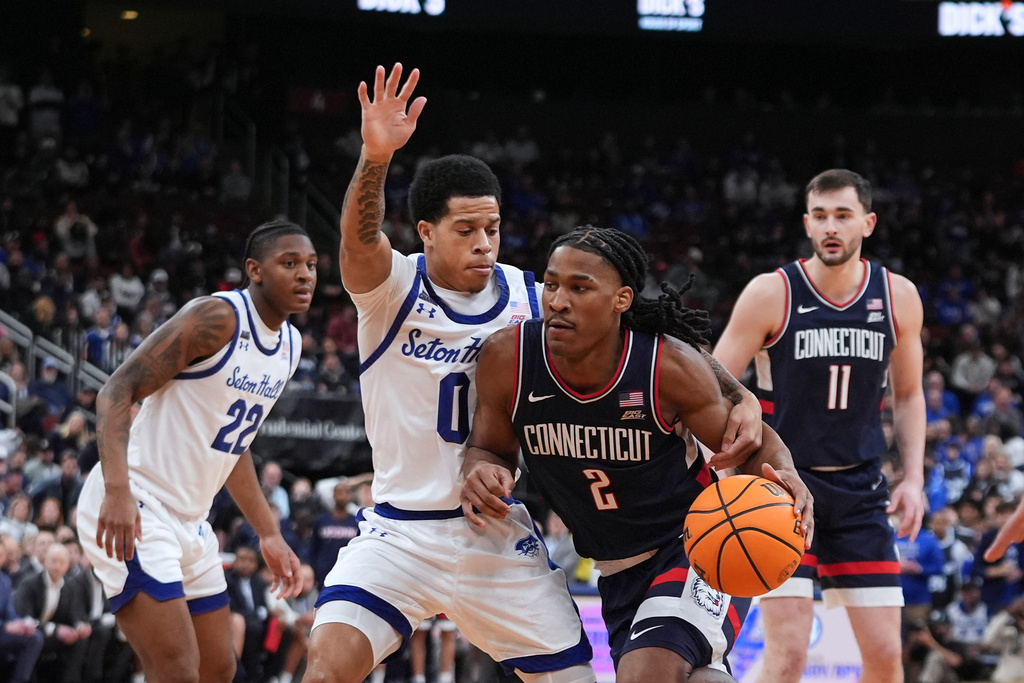 UConn's Silas Demary Jr. (2) drives past Seton Hall's Adam Clark (0) during the first half of an NCAA basketball game Tuesday, Jan. 13, 2026, in Newark, N.J. (AP Photo/Frank Franklin II)