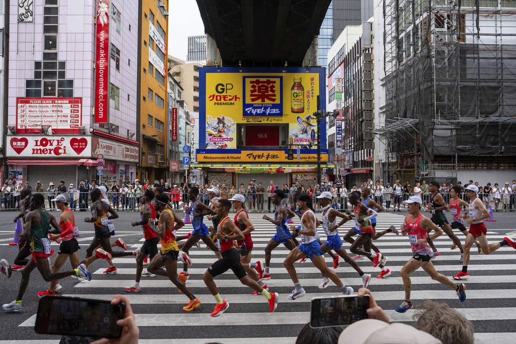 Competitors race through the streets in the men's marathon at the World Athletics Championships in Tokyo, Monday, Sept. 15, 2025. (AP Photo/Louise Delmotte)