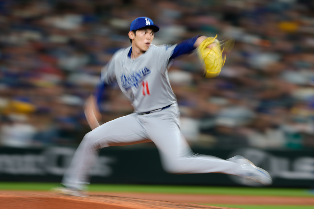 Los Angeles Dodgers relief pitcher Roki Sasaki delivers a pitch during the seventh inning of a baseball game against the Seattle Mariners, Friday, Sept. 26, 2025, in Seattle. (AP Photo/Ryan Sun)