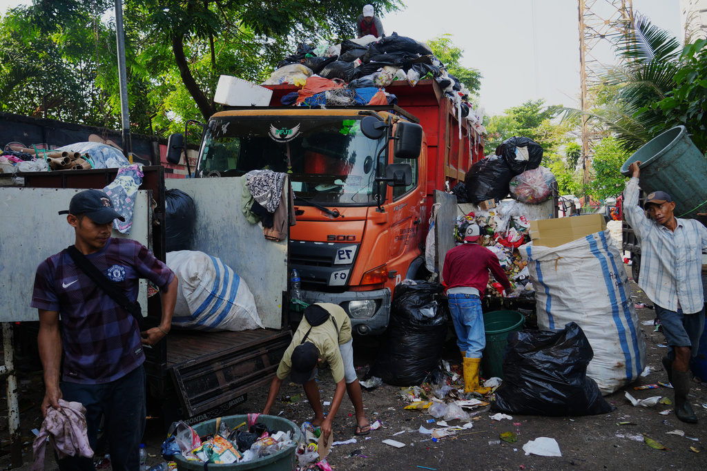 Workers load garbage onto a truck at temporary waste disposal site in Jakarta, Indonesia Friday, July 17, 2026. (AP Photo/Tatan Syuflana)