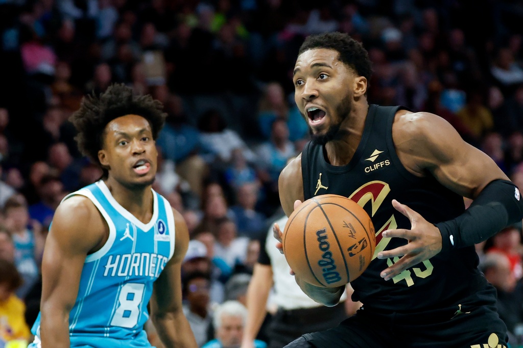 Cleveland Cavaliers guard Donovan Mitchell, right, drives to the basket past Charlotte Hornets guard Collin Sexton during the first half of an NBA basketball game in Charlotte, N.C., Wednesday, Jan. 21, 2026. (AP Photo/Nell Redmond)
