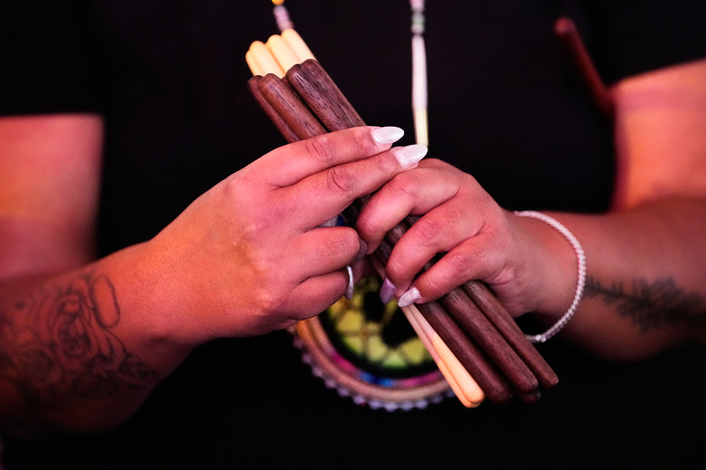 Councillor Charlene Roberds of the Penticton Indian Band holds sticks while explaining the rules of stick-games before a Stick-Games Tournament hosted by the Puyallup Tribe in partnership with World Cup host city Seattle, Saturday, June 27, 2026, in Tacoma, Wash. (AP Photo/Lindsey Wasson)