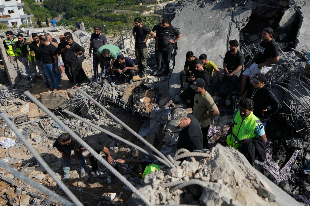 Residents gather as others search through the rubble of houses damaged by an Israeli airstrike in the village of Saksakieh, southern Lebanon, Saturday, May 9, 2026. (AP Photo/Mohammed Zaatari)