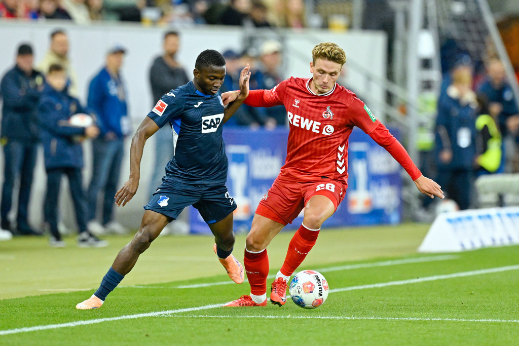 Hoffenheim's Bazoumana Touré, left, and Koln's Sebastian Sebulonsen fight for the ball during the Bundesliga soccer match between Hoffenheim and Koln, at the PreZero Arena in Sinsheim, Germany, Friday Oct. 3, 2025. (Uwe Anspach/dpa via AP)