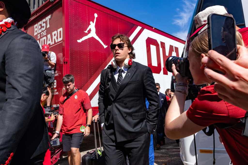 Oklahoma quarterback John Mateer disembarks the team bus and walks into the Cotton Bowl before an NCAA college football game against Texas, Saturday, Oct. 11, 2025, in Dallas. (AP Photo/Jeffrey McWhorter)