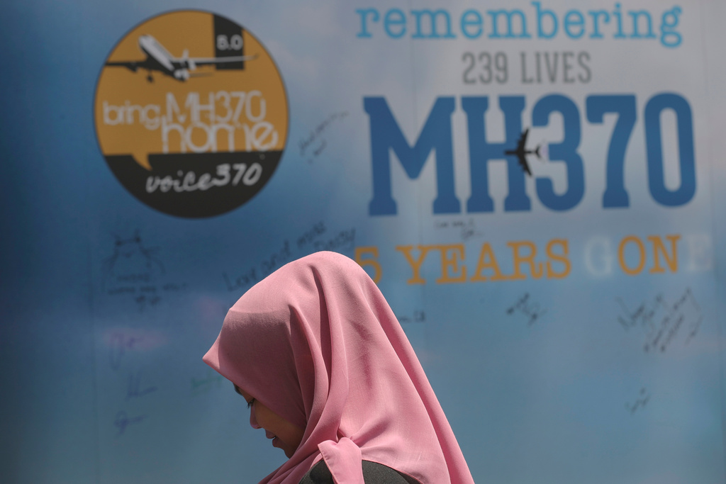FILE - A girl stands in front of a condolence message board during a Day of Remembrance for MH370 event in Kuala Lumpur, Malaysia, on March 3, 2019. (AP Photo/Vincent Thian, File)