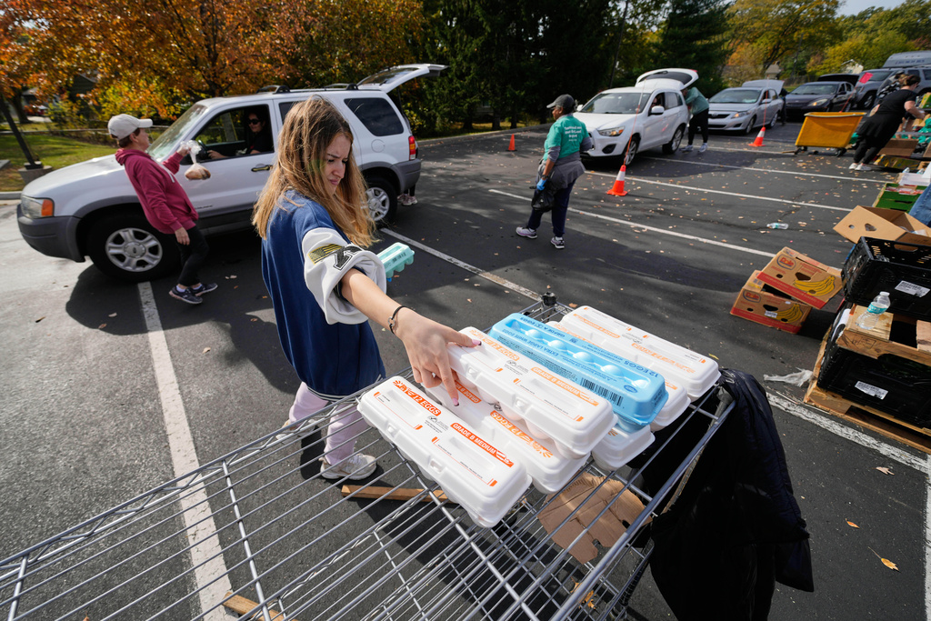 Volunteer Leticia Hassani gathers eggs to distribute to people at a drive-through food bank at the New Haven Seventh-Day Adventist Church Tuesday, Nov. 4, 2025, in Overland Park, Kan. (AP Photo/Charlie Riedel)