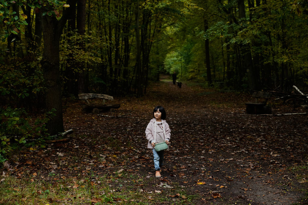 Angela Zhu 5, who is on a mushroom hunting trip with her parents, searches for mushrooms in a forest in Potsdam, Germany, Wednesday, Oct. 8, 2025. (AP Photo/Ebrahim Noroozi)