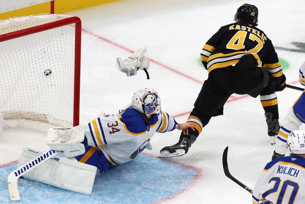 Buffalo Sabres' Alex Lyon (34) loses his glove while blocking a shot by Boston Bruins' Mark Kastelic (47) during the second period of an NHL hockey game, Saturday, Oct. 11, 2025, in Boston. (AP Photo/Michael Dwyer)