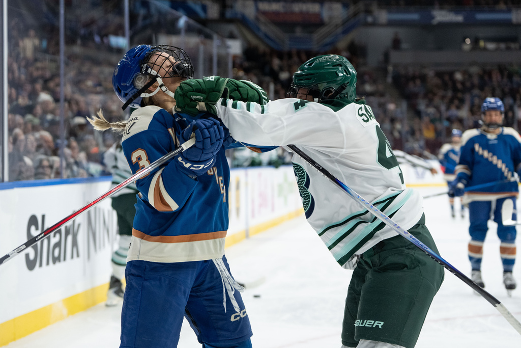 Vancouver Goldeneyes' Tereza Vanisova (13) is pushed by Boston Fleet's Jill Saulnier (44) during the first period of a PWHL game in Vancouver, on Tuesday, March 10, 2026. (Ethan Cairns/The Canadian Press via AP)