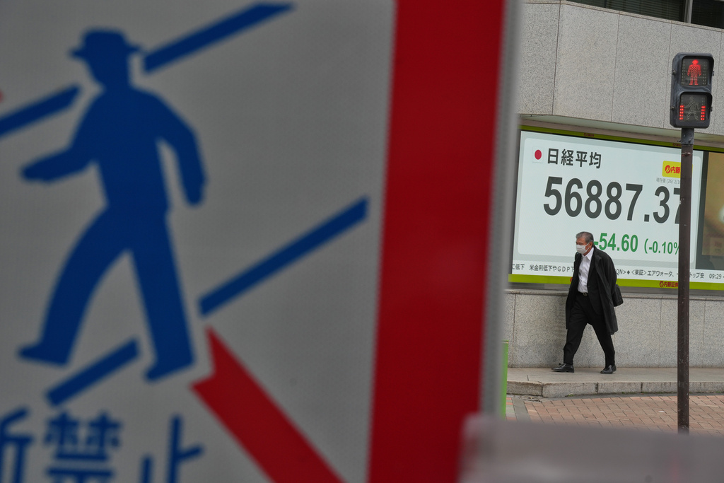 A person walks in front of an electronic stock board showing Japan's Nikkei index at a securities firm Monday, Feb. 16, 2026, in Tokyo. (AP Photo/Eugene Hoshiko)