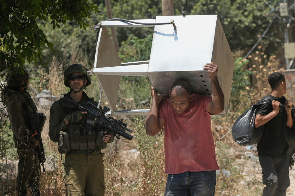 Palestinians collect their belongings from their evacuated homes after the Israeli army issued a number of short term access permits for residents of the occupied West Bank refugee camp of Tulkarem, Wednesday, June 17, 2026. (AP Photo/Majdi Mohammed)