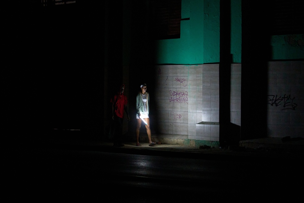 People walk on a street during a blackout in Havana, Cuba, Saturday, March 21, 2026. (AP Photo/Ramon Espinosa)