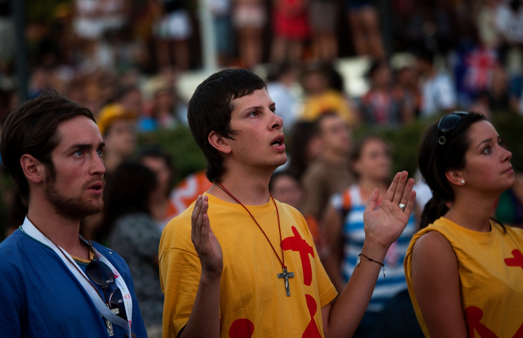 FILE - Pilgrims pray in the street during a mass at the Cibeles square in Madrid, Aug. 16, 2011, ahead of the visit of Pope Benedict XVI. (AP Photo/Emilio Morenatti, File)
