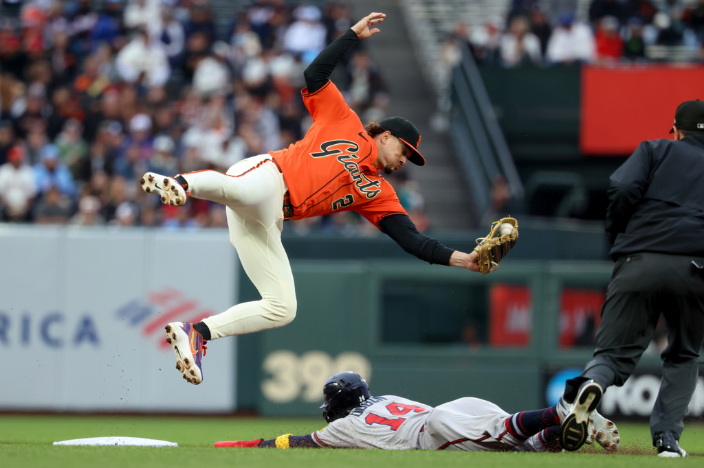 Atlanta Braves' Mauricio Dubón (14) steals second base as San Francisco Giants shortstop Willy Adames (2) fields the throw during the first inning of a baseball game in San Francisco, Friday, June 26, 2026. (AP Photo/Jed Jacobsohn)