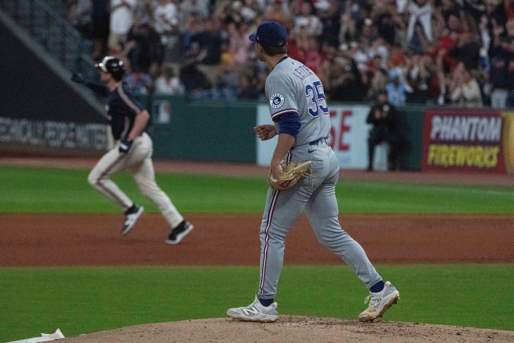 Texas Rangers starting pitcher Jack Leiter, foreground watches Cleveland Guardians' Kyle Manzardo round the bases after hitting a two-run home run during the first inning of a baseball game, Friday, Sept. 26, 2025, in Cleveland. (AP Photo/Phil Long)