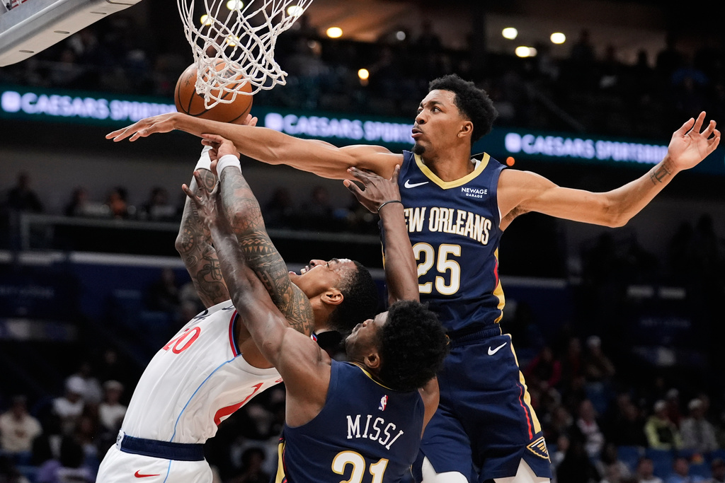 Los Angeles Clippers forward John Collins (20) is stopped driving to the basket against New Orleans Pelicans forward Trey Murphy III (25) and center Yves Missi (21) in the first half of an NBA basketball game, Wednesday, March 18, 2026, in New Orleans. (AP Photo/Gerald Herbert)