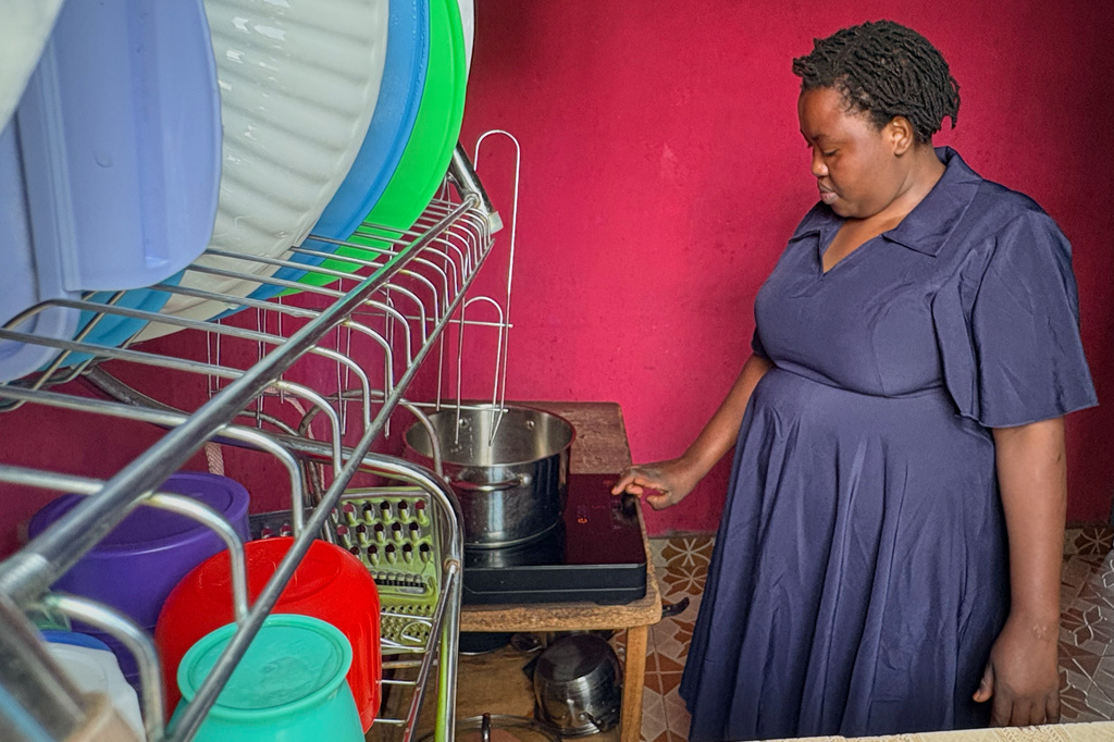Mary Kavutha prepares breakfast using a fuel-efficient cookstove made by BURN in Kiambu, Kenya, on July 31, 2026. (AP Photo/Allan Olingo)