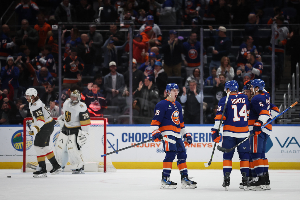New York Islanders players celebrate a goal by Bo Horvat (14) during the first period of an NHL hockey game against the Vegas Golden Knights, Tuesday, Dec. 9, 2025, in Elmont, N.Y. (AP Photo/Heather Khalifa)