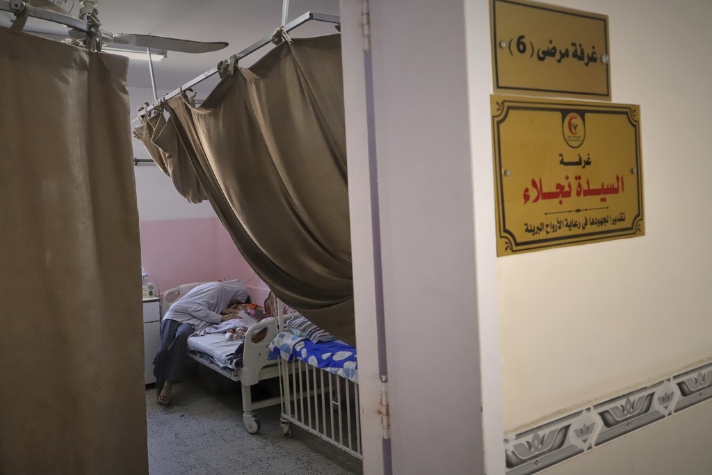 FILE - Nour al-Hams cares for her 3-year-old nephew, Amr al-Hams, who lies in a hospital bed with brain damage caused by an Israeli strike on his family's tent in April, at Nasser Hospital in Khan Younis, Gaza Strip, Wednesday, June 25, 2025. (AP Photo/Mariam Dagga, File)