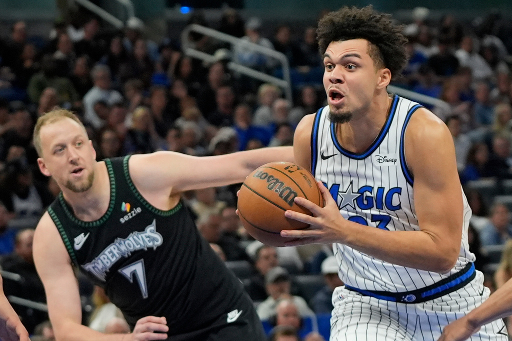 Orlando Magic forward Noah Penda, right, drives past Minnesota Timberwolves forward Joe Ingles (7) during the second half of an NBA basketball game, Wednesday, April 8, 2026, in Orlando, Fla. (AP Photo/John Raoux)
