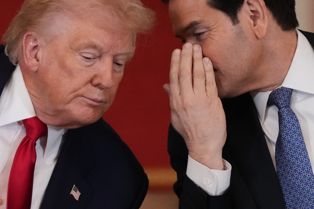 President Donald Trump speaks with Secretary of State Marco Rubio during a roundtable discussion on college sports in the East Room of the White House, Friday, March 6, 2026, in Washington. (AP Photo/Julia Demaree Nikhinson)