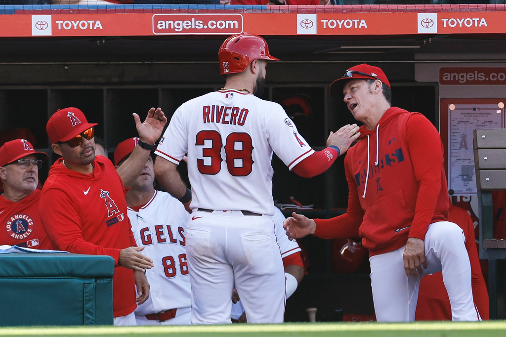 Los Angeles Angels' Sebastian Rivero (38) is greeted at the dugout after scoring on an RBI single hit by teammate Mike Trout during the third inning of a baseball game against the Texas Rangers, Sunday, May 24, 2026, in Anaheim, Calif. (AP Photo/Caroline Brehman)