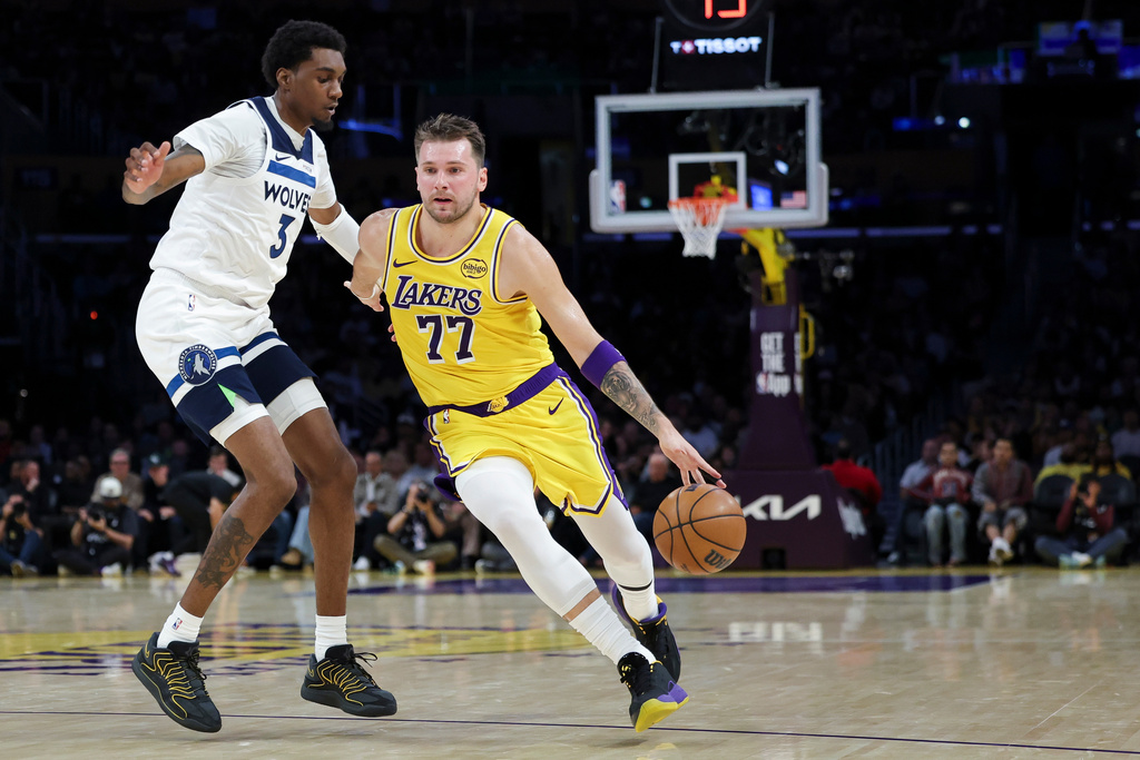 Los Angeles Lakers guard Luka Doncic (77) dribbles against the Minnesota Timberwolves forward Jaden McDaniels (3) during the first half of an NBA basketball game, Friday, Oct. 24, 2025, in Los Angeles. (AP Photo/Jessie Alcheh)