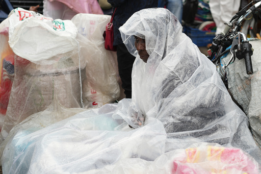 A street vendor covers up in plastic during a light rain in the Petion-Ville neighborhood of Port-au-Prince, Haiti, Tuesday, Oct. 28, 2025, as Hurricane Melissa passes through the Caribbean. (AP Photo/Odelyn Joseph) A street vendor covers up in plastic during a light rain in the Petion-Ville neighborhood of Port-au-Prince, Haiti, Tuesday, Oct. 28, 2025, as Hurricane Melissa passes through the Caribbean. (AP Photo/Odelyn Joseph)