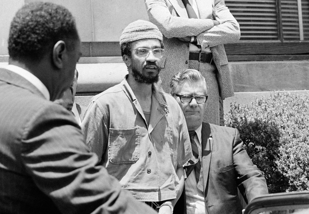 FILE - H. Rap Brown is escorted to a car by federal officers in New Orleans, June 2, 1972, after he was sentenced to five years in prison on a federal gun control conviction. Brown is also facing charges in New York in connection with a tavern holdup. (AP Photo/Jack Thornell, File)