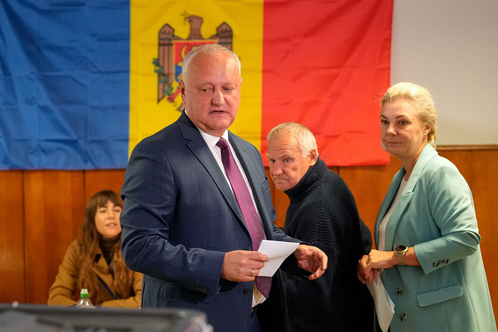 Former Moldovan President Igor Dodon, left, and his wife Galina prepare to cast their vote during a parliamentary election, in Chisinau, Moldova, Sunday, Sept. 28, 2025. (AP Photo/Vadim Ghirda)