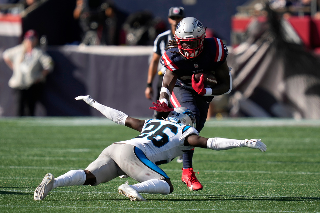 New England Patriots running back Rhamondre Stevenson, top, runs against Carolina Panthers cornerback Chau Smith-Wade (26) during the second half of an NFL football game, Sunday, Sept. 28, 2025, in Foxborough, Mass. (AP Photo/Charles Krupa)