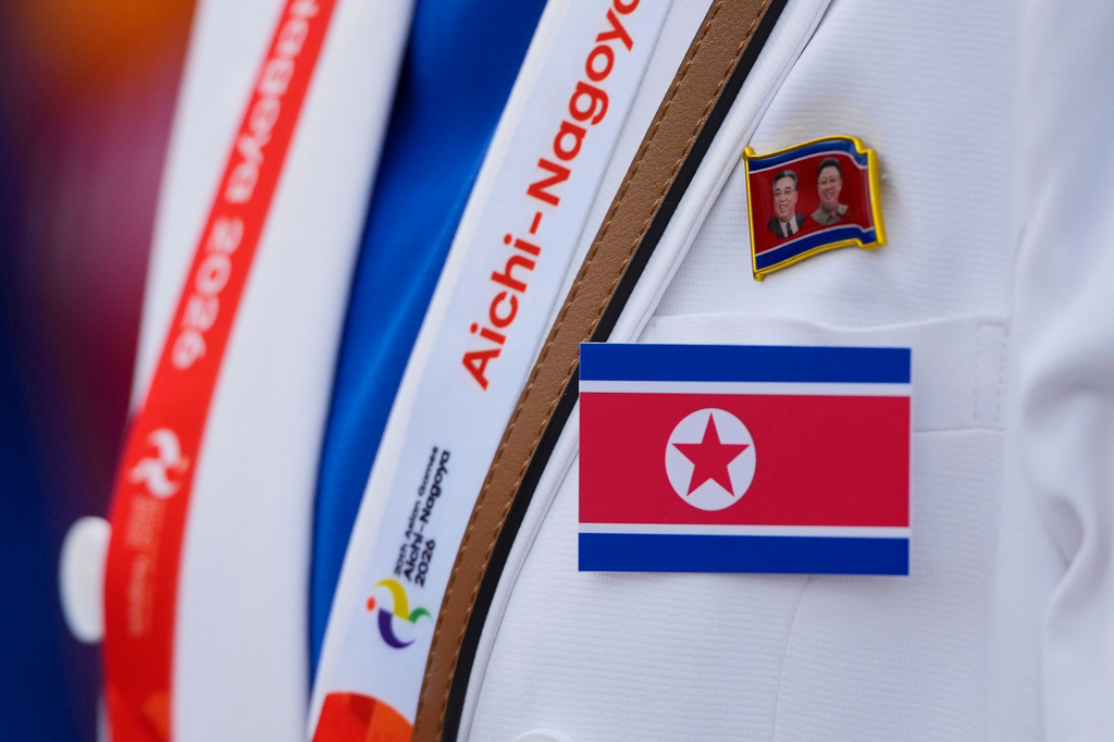 A North Korean offical wears their national flag during a ceremony for the Asian Games at the athletes village in Nagoya, Japan, Friday, Sept. 18, 2026. (AP Photo/Dita Alangkara)
