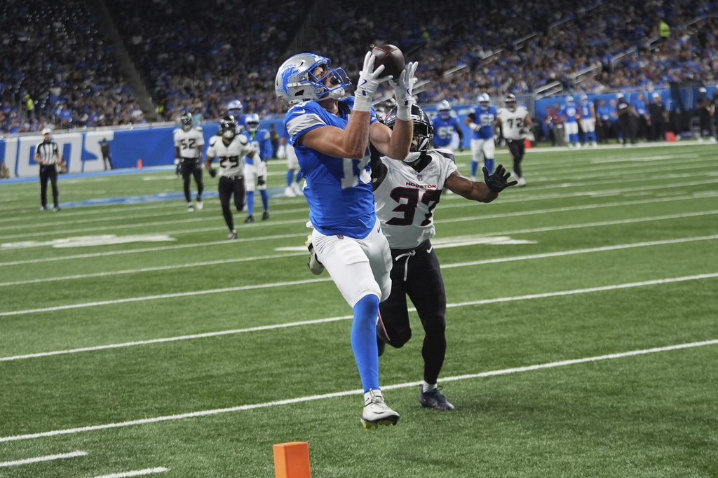 Detroit Lions wide receiver Isaac TeSlaa (18) catches a pass for a touchdown as Houston Texans cornerback D'Angelo Ross (37) defends during the first half of an NFL football game Saturday, Aug. 23, 2025, in Detroit. (AP Photo/Paul Sancya)