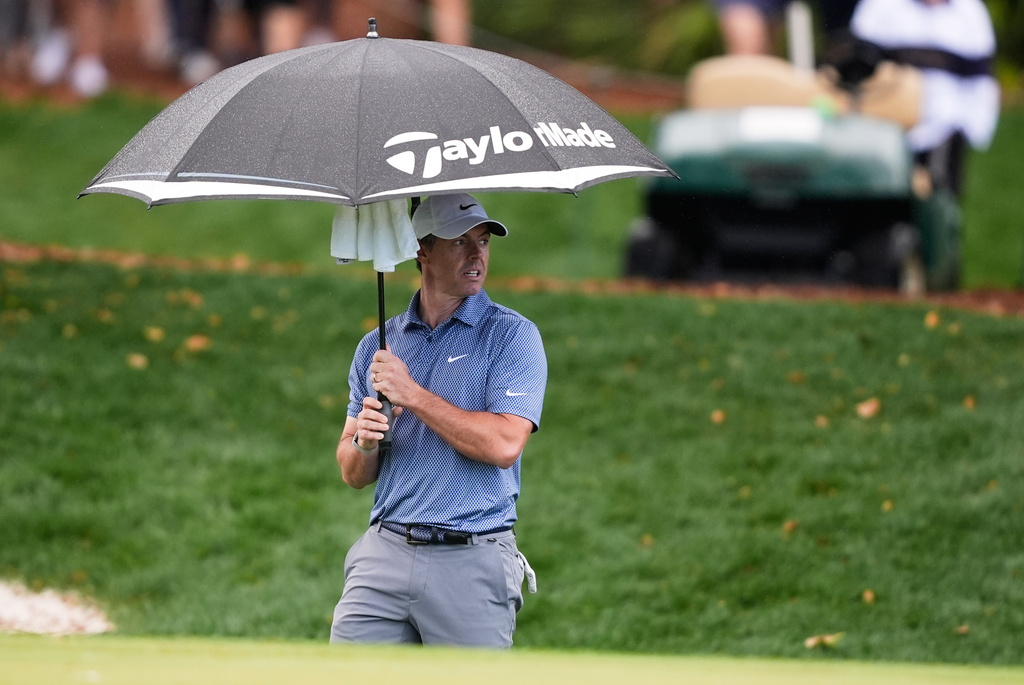 Rory McIlroy of Northern Ireland stands under an umbrella on the ninth fairway during the first round of The Players Championship golf tournament Thursday, March 12, 2026, in Ponte Bedra Beach, Fla. (AP Photo/Gerald Herbert)
