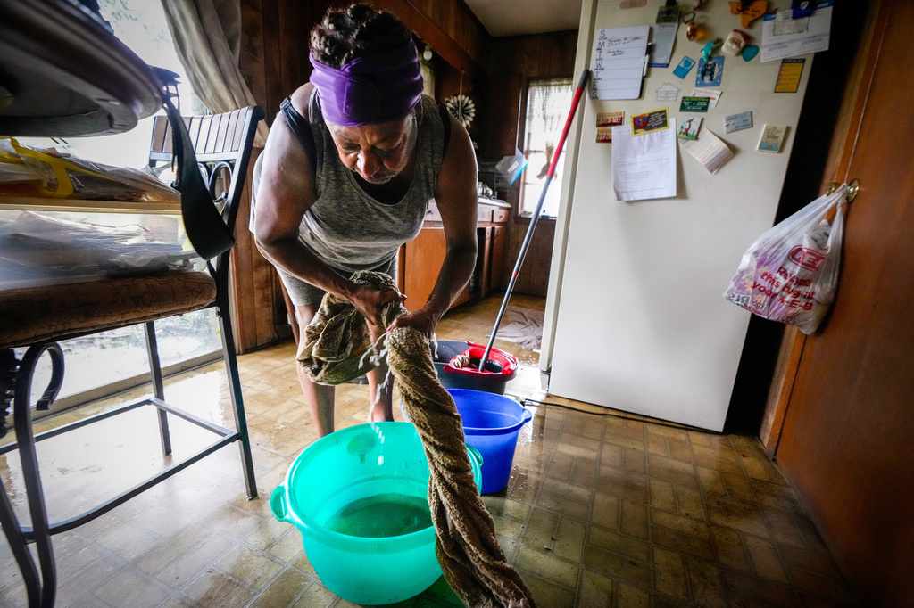 Bendy Lee squeezes water out of a towel as she cleans her kitchen after a tree fell on her roof, causing rain to come inside, in the aftermath of Tropical Storm Edouard in Kountze, Texas, Wednesday, Sept. 2, 2026. (Brett Coomer/Houston Chronicle via AP)