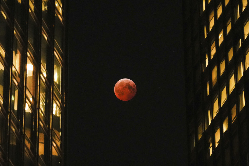 FILE - A total lunar eclipse, known as the blood moon, is visible between skyscrapers Friday, March 14, 2025, in downtown Chicago. (AP Photo/Kiichiro Sato, File)