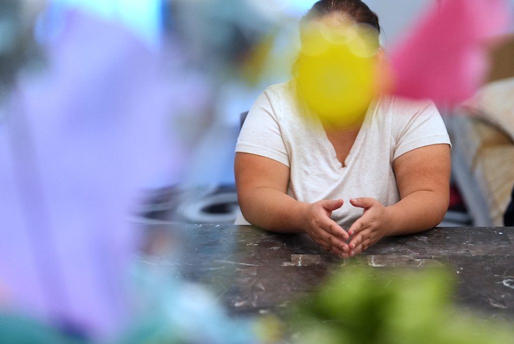 Blanca, a 38-year-old math teacher from Mexico who crossed the border with her three children in 2024 and has applied for asylum, sits at a table inside the family's rented two-bedroom duplex in Apopka, Fla., Wednesday, Aug. 20, 2025. (AP Photo/Rebecca Blackwell)