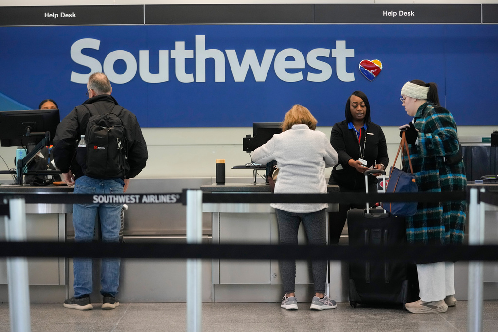 Travelers check in with Southwest Airlines at Midway International Airport, Tuesday, Jan. 27, 2026, in Chicago. (AP Photo/Erin Hooley)