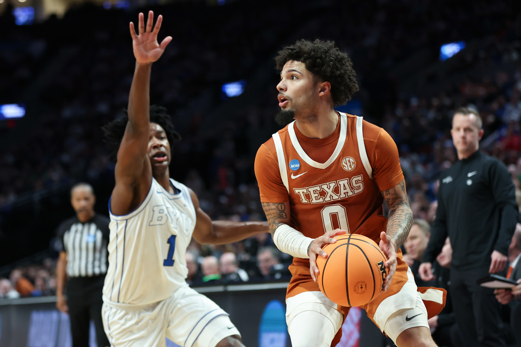 Texas guard Jordan Pope (0) looks to shoot as BYU guard Robert Wright III (1) defends during the first half in the first round of the NCAA college basketball tournament Thursday, March 19, 2026, in Portland, Ore. (AP Photo/Amanda Loman)